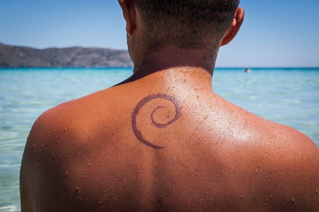 A tanned person with a Debian Linux tattoo on his back